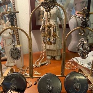 THREE VSA VINTAGE NECKLACES with compact containers and cross metal stand 700.00